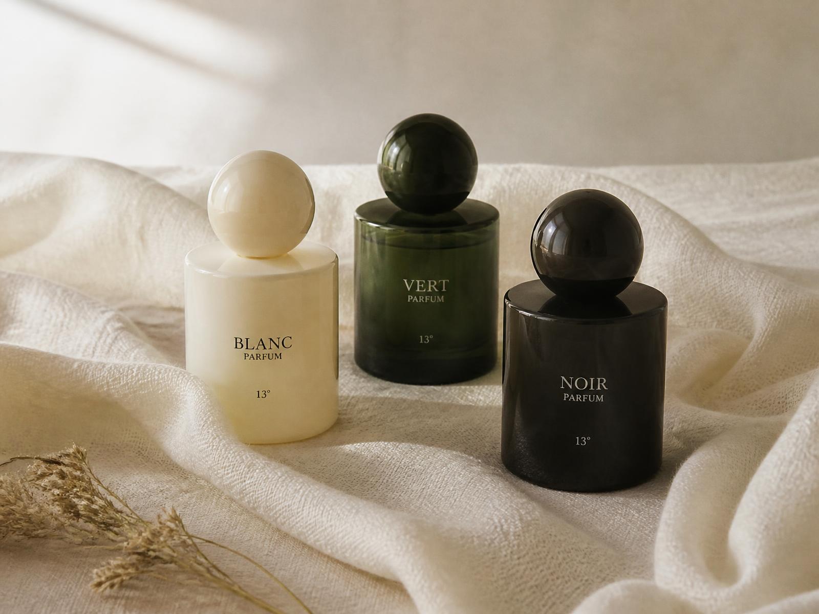 Three Eyas & Co. bottles in ivory, forest green and noir glass